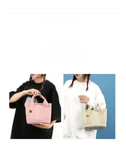 Detail of pink and beige canvas mini tote bags with multiple pockets and metal pendant