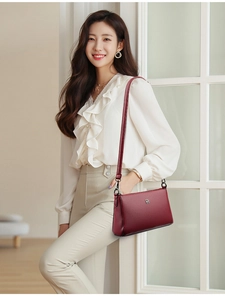 Detail of dark red crossbody bag with lychee grain leather and vintage square logo