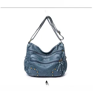 Front detail of navy blue PU crossbody bag featuring retro texture and bronze rivets
