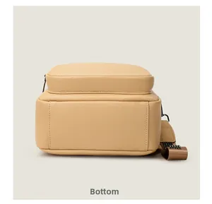 Vista detallada del fondo de la mochila de cuero granulado beige con remaches de metal