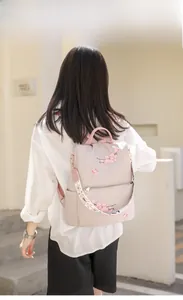 Detailed back view of nylon backpack with cherry blossom embroidery and wide ethnic strap