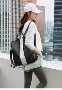 Outdoor street view of a woman wearing a black textured leather backpack with white stripes