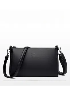 Detail of classic black litchi texture leather handbag with silver square metal logo