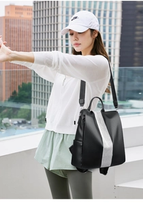 Detail of black pebbled leather backpack with silver sequin stripes and adjustable straps
