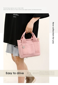 Detail of light pink canvas tote bag featuring reinforced handles and a metal charm pendant