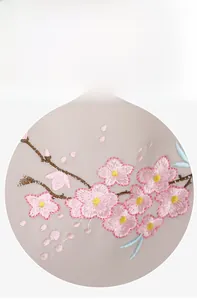 Close-up of pink floral embroidery and delicate texture on light fabric backpack