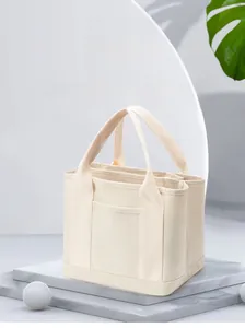 Detail of off-white canvas bag with multi-compartment design and water-resistant fabric