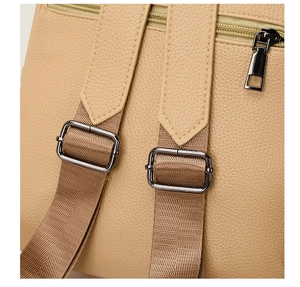 Close-up of adjustable shoulder straps and textured leather on a beige backpack