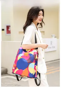 Detailed view of colorful polka dot oxford backpack on model against yellow wall