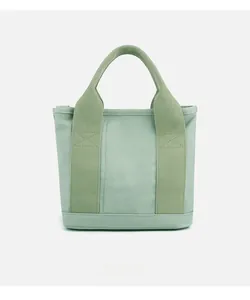 Detail view of mint green canvas tote bag with textured fabric and reinforced stitching