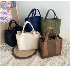 Detailed view of canvas tote bags in multiple colors with multi-compartment storage