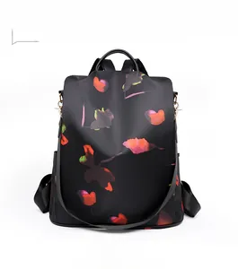 Front detail of black oxford backpack featuring vibrant orange leaf prints and top handle