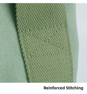 Close-up of reinforced cross-stitching on durable light green canvas handbag straps