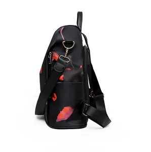 Detail view of floral Oxford backpack featuring gold zippers and adjustable nylon straps