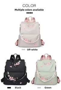 Detail view of nylon backpacks featuring cherry blossom embroidery in white, black, and green