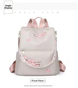 Front view of light grey nylon backpack featuring pink cherry blossom embroidery