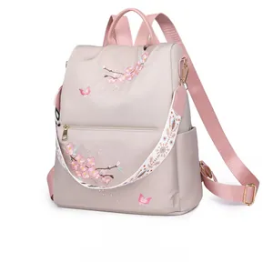 Detail of pink nylon backpack with cherry blossom embroidery and ethnic woven strap