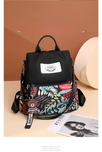 Detail view of printed waterproof backpack featuring floral patterns and a cute bear charm
