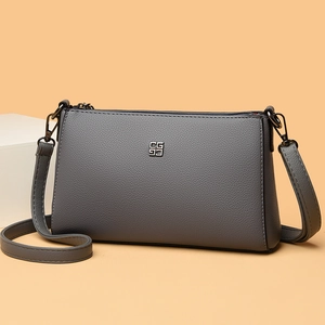 Minimalist grey leather crossbody bag with silver hardware and adjustable strap