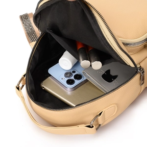 Beige textured leather backpack showing large capacity for phone, tablet, and cosmetics