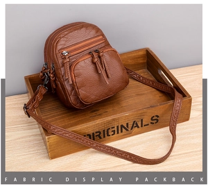 Brown PU leather crossbody bag with three zipper compartments and tassel detail