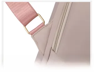 Detailed close-up of high-quality light gold metal buckle and reinforced stitching on pink backpack