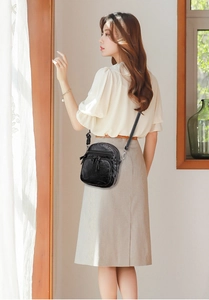 Close-up of black PU leather crossbody bag with dual zipper pockets and slim strap