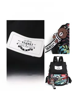 Detail of printed floral backpack featuring a brand label and cute bear charm pendant