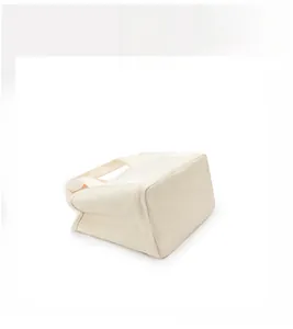 Flat angle view showing the square bottom and sturdy canvas texture of the beige handbag