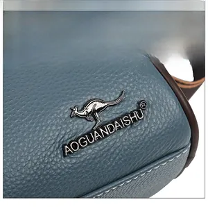 Détail de la texture cuir grainé avec logo kangourou en métal sur le sac à main