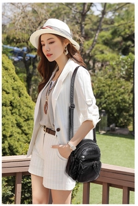 Casual black soft PU leather crossbody bag with multiple zippers shown on a model outdoors