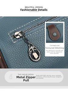 Détail du sac bandoulière en cuir bleu foncé avec ferrures argentées et coutures blanches