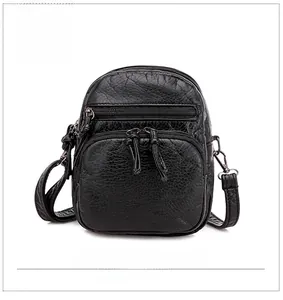 Detailed view of black soft PU leather texture and multiple front zipper pockets