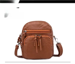 Detailed front view of brown litchi pattern PU leather crossbody bag with triple zippers