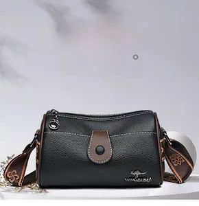 Détail d'un sac bandoulière en cuir grainé noir avec logo kangourou et sangle tissée