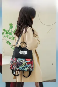 Detail of waterproof backpack showing tropical print pocket and cute bear charm pendant