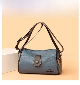 Détail du sac en cuir grainé bleu-gris avec logo kangourou et bandoulière tissée