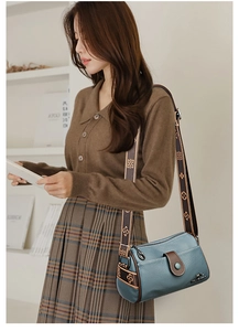 Sac bandoulière en cuir bleu avec rabat marron et large sangle imprimée sur modèle