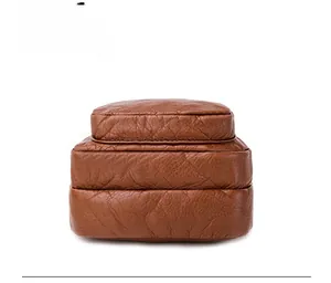 Close-up of the triple-layered bottom design on brown litchi grain faux leather bag