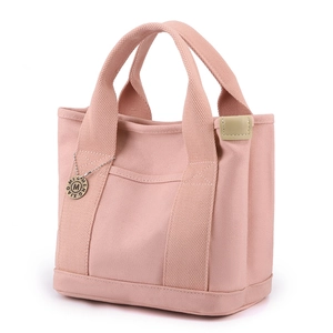 Pink canvas tote bag with dual handles and M-letter charm pendant for daily casual use