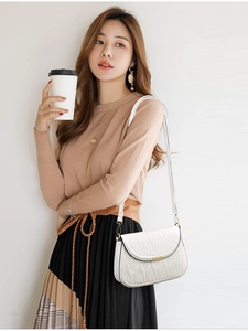 Detailed view of white quilted PU leather crossbody bag with gold metal buckle hardware