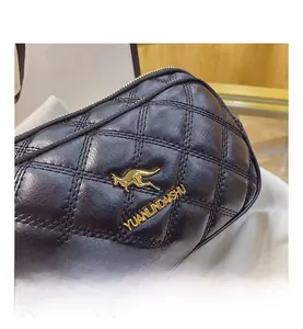 Detailed view of quilted black leather bag with golden kangaroo logo and metal accents