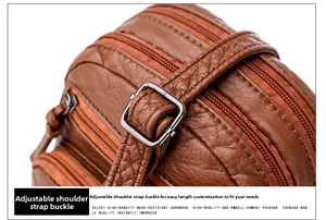 Detail of adjustable metal buckle and textured leather strap on brown shoulder bag