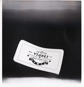 Detail of white logo patch with YIQBEI text on a black lightweight nylon backpack