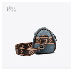 Vue latérale du sac en cuir gris-bleu avec bandoulière fleurie en jacquard et zip argenté