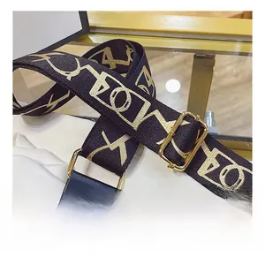 Detail of wide adjustable black and gold jacquard shoulder strap with metal hardware