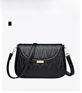 Front view of black quilted PU leather shoulder bag with gold metal plate and wave stitching