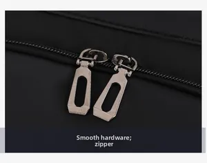 Close-up of smooth dual metal zippers and textured black nylon fabric of the backpack
