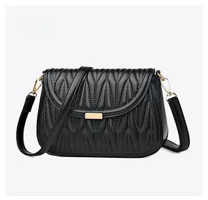 Micro side view of black quilted PU leather crossbody bag with gold buckle detail