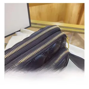 Detailed close-up of three smooth golden zippers on a black quilted crossbody bag